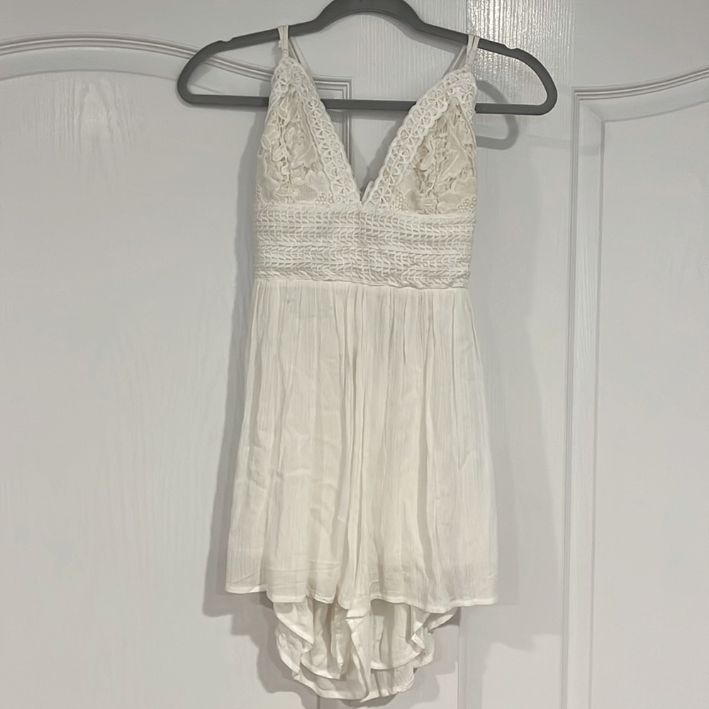 The brand is ILLA ILLA, medium size, white romper
